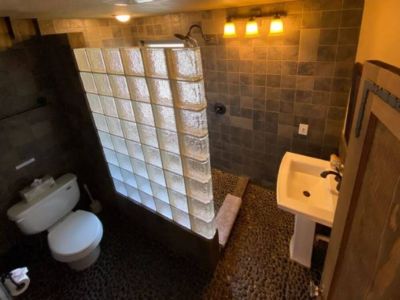 The next best thing to showering outdoors is this private upstairs bathroom with its pebbled floor and rain head shower.