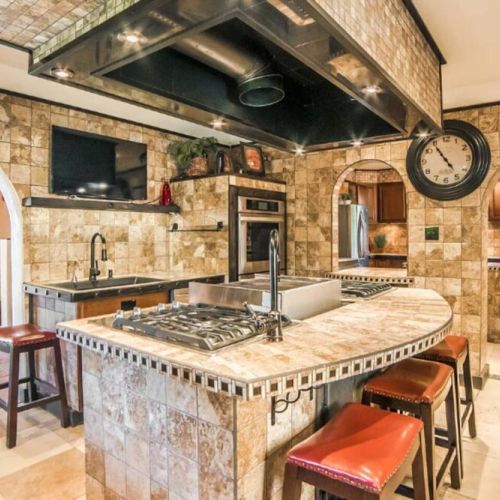The Chef Kitchen's large island boasts 8 gas burners, a convenient pot filler, and indoor grill with gleaming countertops to an array of top-of-the-line appliances.