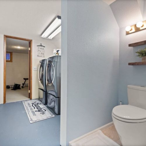 Tucked away in the basement laundry area is a bathroom sink and toilet.
