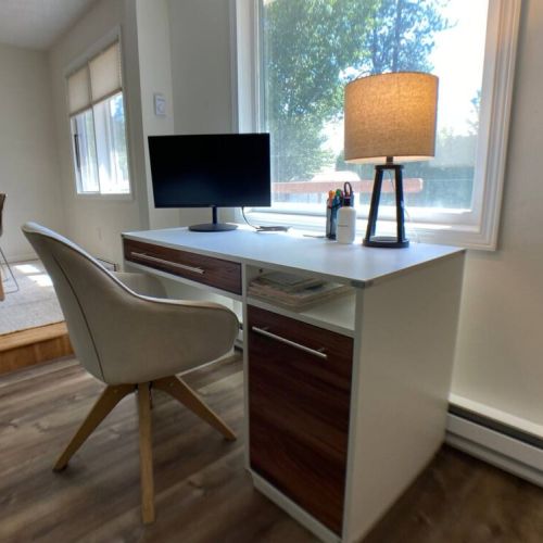 Working from home is easy with the full desk, upholstered swivel chair, and computer monitor.