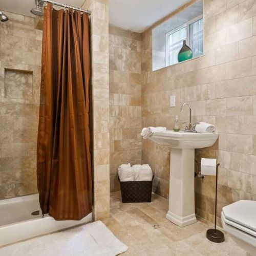 The bathroom on the lower-level features travertine floors with radiant heating.  This eco-friendly natural stone is a non-allergenic, making it suitable for individuals with allergies or respiratory sensitivities.