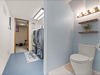 Tucked away in the basement laundry area is a bathroom sink and toilet.
