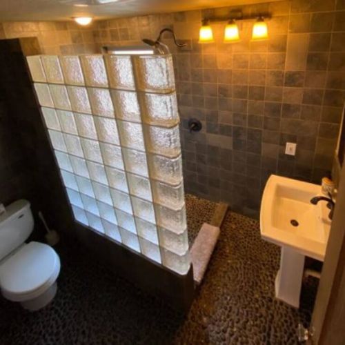 The next best thing to showering outdoors is this private upstairs bathroom with its pebbled floor and rain head shower.