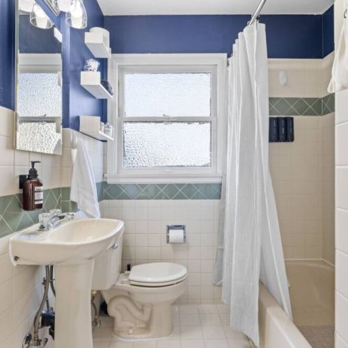 Main floor full bathroom with its original 1945 charm and modern amenities.