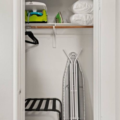 The  queen bedroom closet has a Graco Pack n Play, fitted Graco sheet, child booster/high chair, iron, ironing board, and a luggage rack.