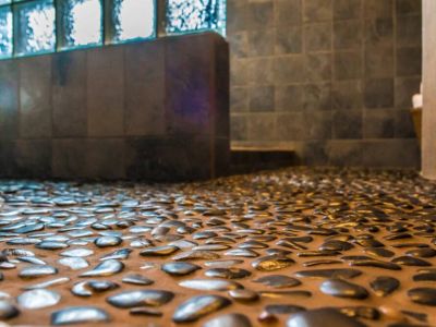 The main bathroom has a walk-in shower with therapeutic black stones inlaid into the floor providing a spa-like experience.