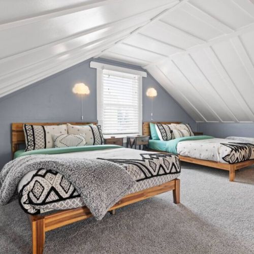 Two full/double beds are nestled in this PNW themed loft bedroom.