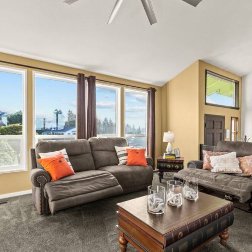 Sit back and relax in the brightly lit living room with electric reclining sofa and chair.