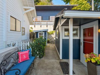 The view of the entrance walkway.  Parking is available in front of the garage (large blue building in background). Stairs lead down to the beach house.