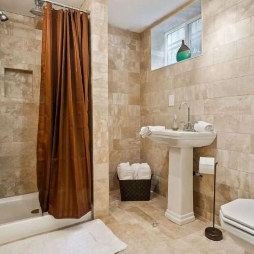 The bathroom on the lower-level features travertine floors with radiant heating.  This eco-friendly natural stone is a non-allergenic, making it suitable for individuals with allergies or respiratory sensitivities.