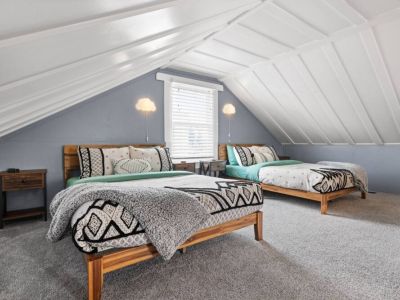 Two full/double beds are nestled in this PNW themed loft bedroom.