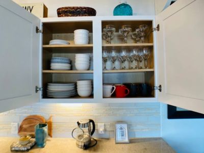 A generous collection of extra cups, glasses, and plates neatly arranged.