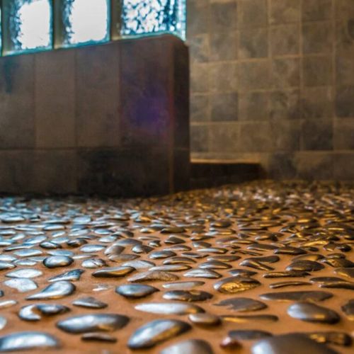 The main bathroom has a walk-in shower with therapeutic black stones inlaid into the floor providing a spa-like experience.