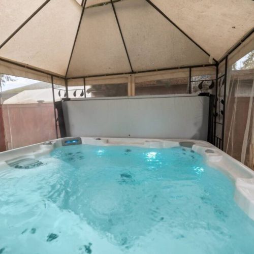 The hot tub is nestled under a canopy for extra privacy as you enjoy the soak.