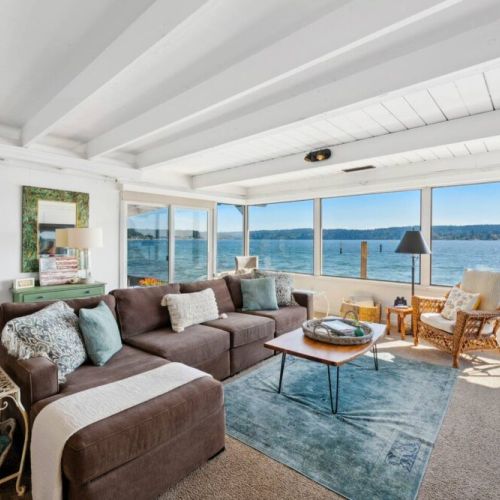 This coastal haven boasts an expansive floor-to-ceiling window that opens up to a mesmerizing ocean view, instantly drawing you into its serene embrace.