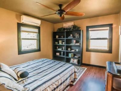 Relax in this upstairs Queen bedroom with a bookcase filled with interesting books and fun, funky finds.