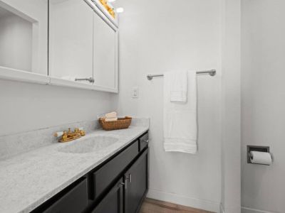 Discover the essence of comfort in this inviting King En Suite bathroom.  The well-appointed space showcases a modern vanity with ample storage, complemented by a stylish mirror and sleek fixtures