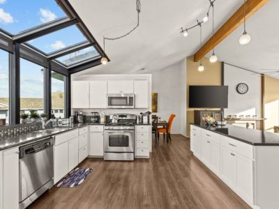 Enjoy cooking in the brightly lit  fully stocked kitchen with its open living space with the living room.