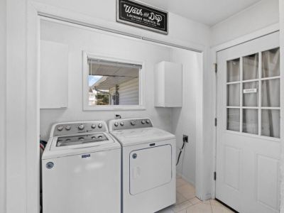 A functional and well-organized laundry room showcasing a sleek washer and dryer duo. The clean and tidy space provides a calming atmosphere for the essential task of laundry, making chores a breeze.