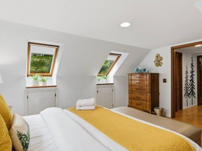 The bedroom is bathed in natural light from angled skylights with views of the treetops. The shades are easily pulled down for darkening the room...or leave up to sleep "under the stars".