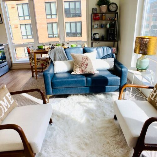 Living Room comfortably seats four with the vegan leather loveseat and two linen club chairs. The faux sheepskin rug is soft and cozy to sit on too.