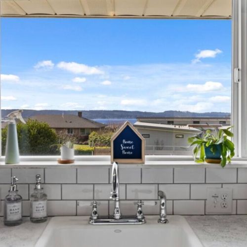 The gleaming sink adds a touch of modern elegance, complemented by the peek-a-boo views of the water (Puget Sound)
