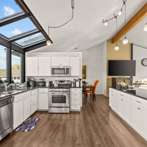 Enjoy cooking in the brightly lit  fully stocked kitchen with its open living space with the living room.