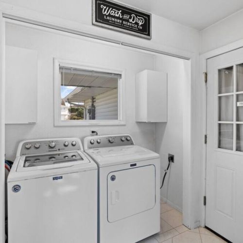 A functional and well-organized laundry room showcasing a sleek washer and dryer duo. The clean and tidy space provides a calming atmosphere for the essential task of laundry, making chores a breeze.