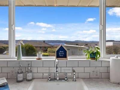 The gleaming sink adds a touch of modern elegance, complemented by the peek-a-boo views of the water (Puget Sound)