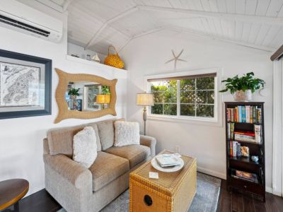 Grab a book and a cup of tea while relaxing in this quaint sitting room just off of the kitchen while enjoying the view of the covered patio and the breeze coming off of the water.
