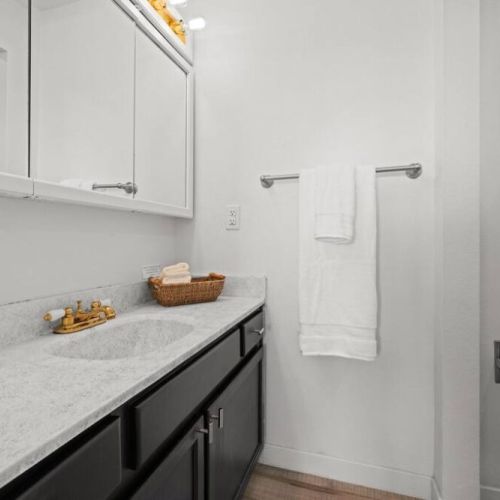 Discover the essence of comfort in this inviting King En Suite bathroom.  The well-appointed space showcases a modern vanity with ample storage, complemented by a stylish mirror and sleek fixtures