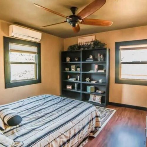 Relax in this upstairs Queen bedroom with a bookcase filled with interesting books and fun, funky finds.