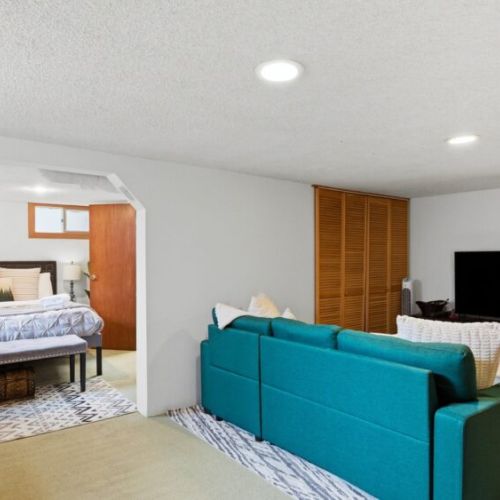 Lower-level game room with queen sleeper sofa and semi-private queen bedroom.