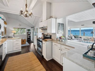 Step into a modern culinary masterpiece, where the pure elegance of white takes center stage in a beautifully designed kitchen.