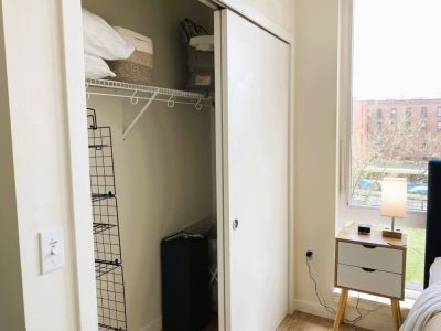 Closet includes extra pillows, hangers, and a wire hanging shelf