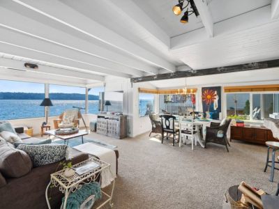 Oversized windows span the entire length of one wall, providing an unobstructed view of the majestic ocean and allowing the warm, natural light to bathe the room in a soft, welcoming glow.