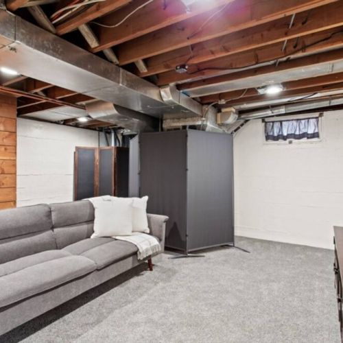 Welcome to our inviting downstairs living room. The comfortable futon couch provides versatile seating while enjoying your favorite shows and movies on the smart TV.