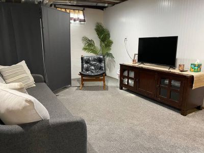 The TV console includes extra pillows and sheets for additional sleeping options.