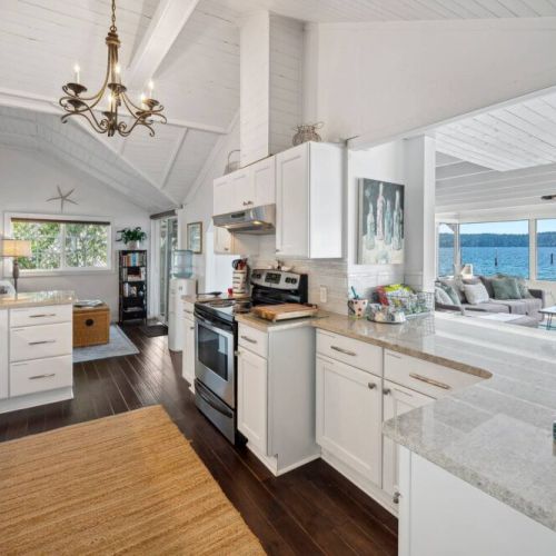 Step into a modern culinary masterpiece, where the pure elegance of white takes center stage in a beautifully designed kitchen.