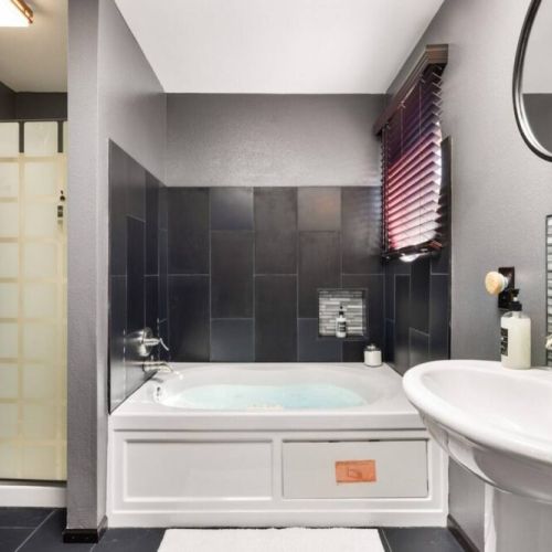 Step into a world of relaxation and luxury in the en suite bathroom of the king bedroom, featuring a jetted Jacuzzi tub and a separate shower.