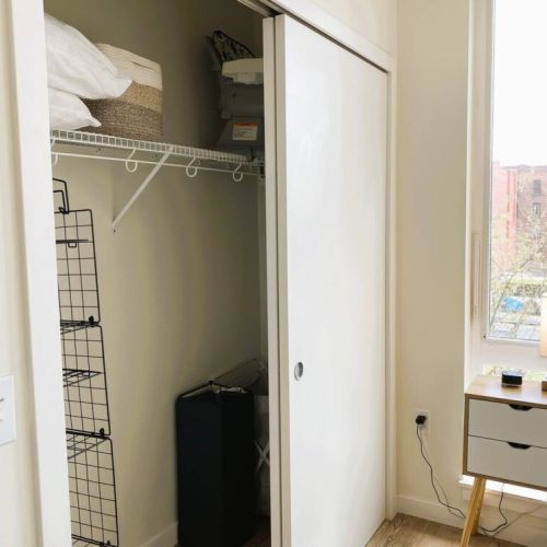 Closet includes extra pillows, hangers, and a wire hanging shelf
